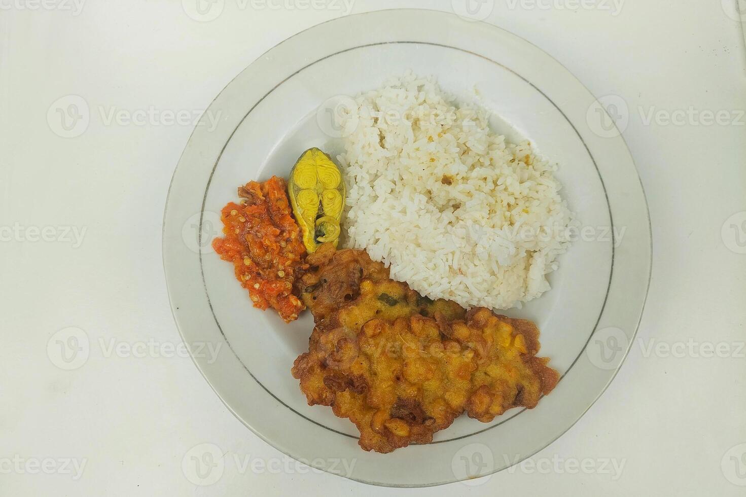 Rice mixed with fried fish and tempeh vegetables on a white plate photo