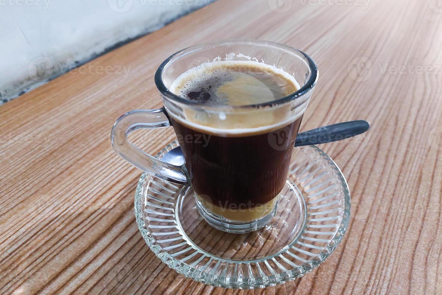 Coffee and milk have not been stirred in a glass on the table photo