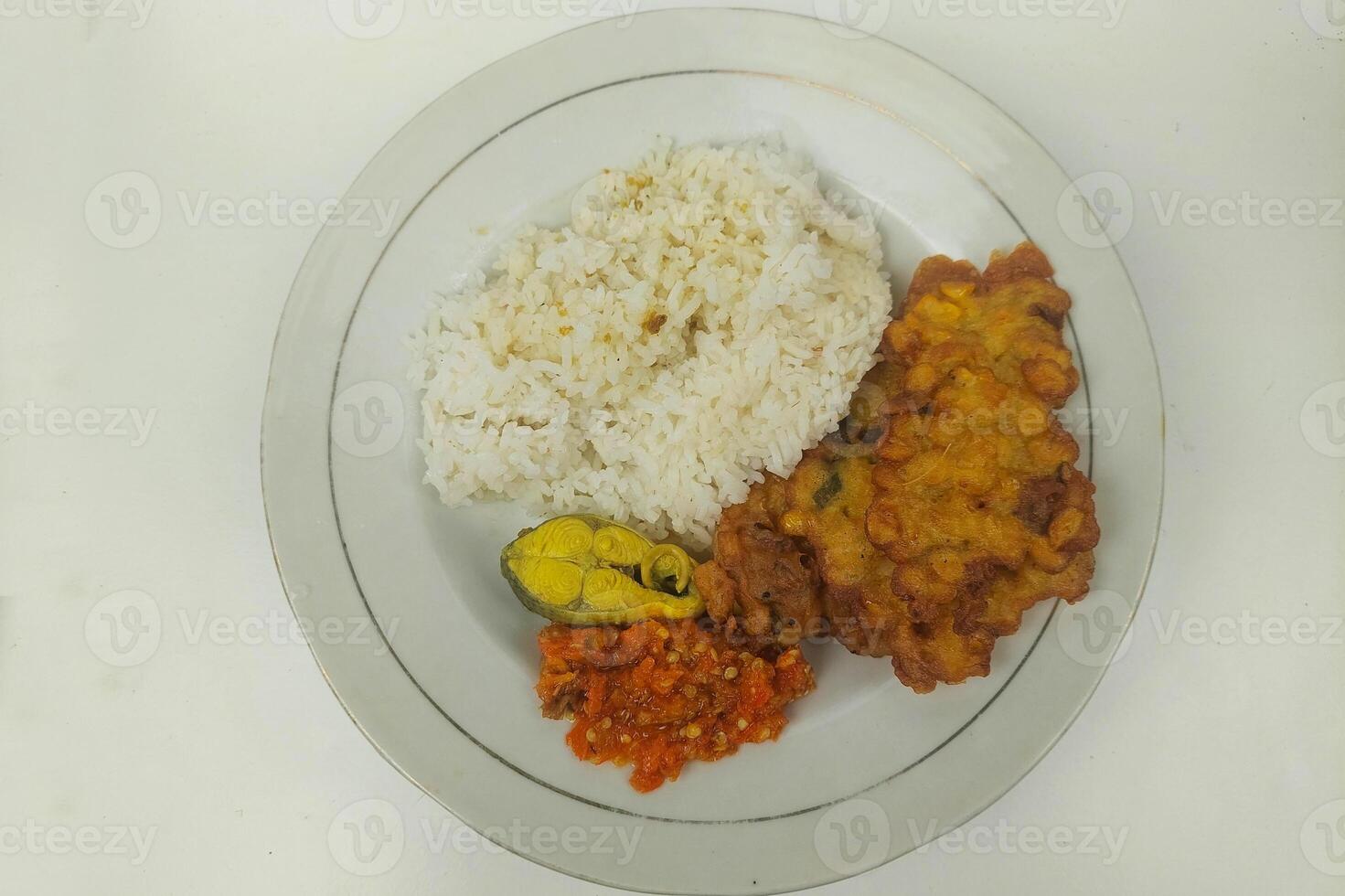 Rice mixed with fried fish and tempeh vegetables on a white plate photo