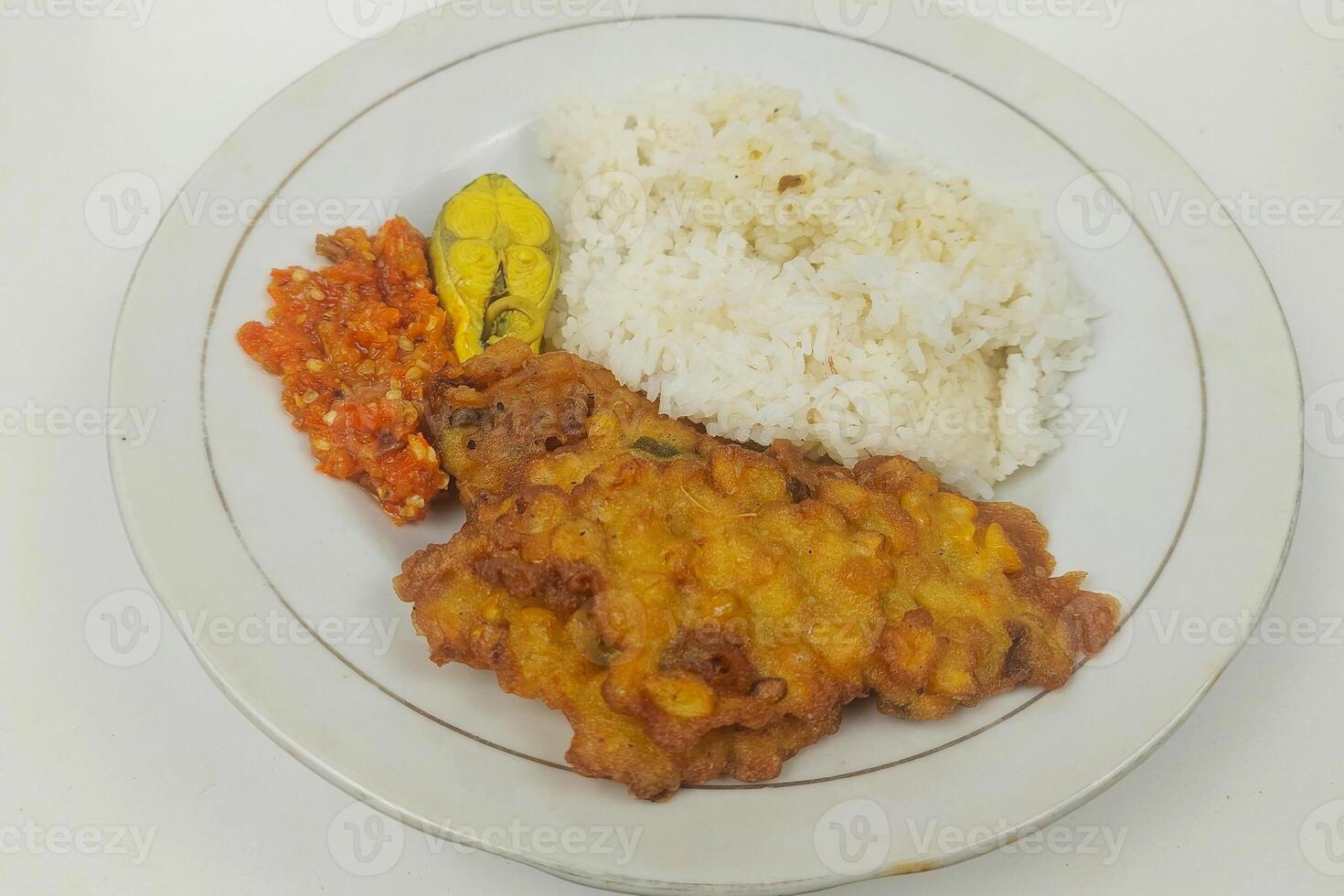Rice mixed with fried fish and tempeh vegetables on a white plate photo
