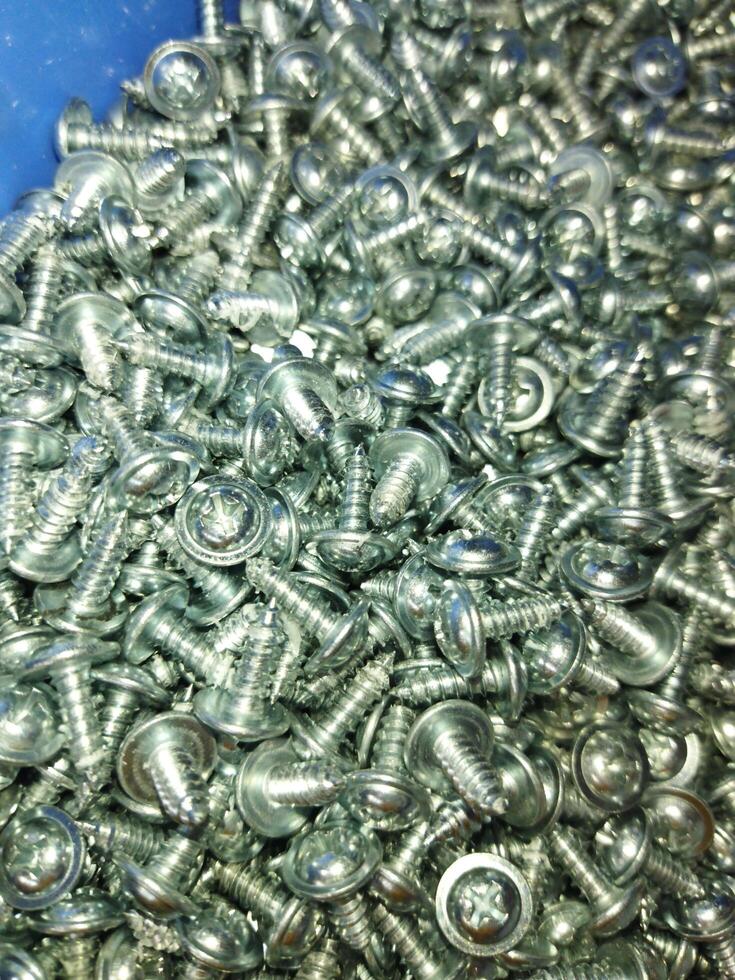 a pile of screws and nuts in a blue container photo
