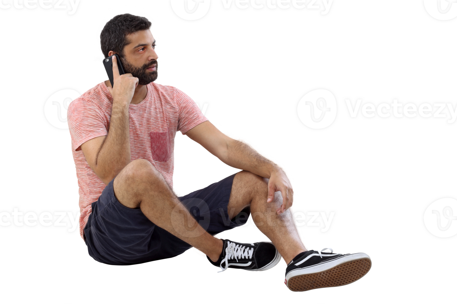 young man sitting on the floor in casual clothes talking on cell phone png
