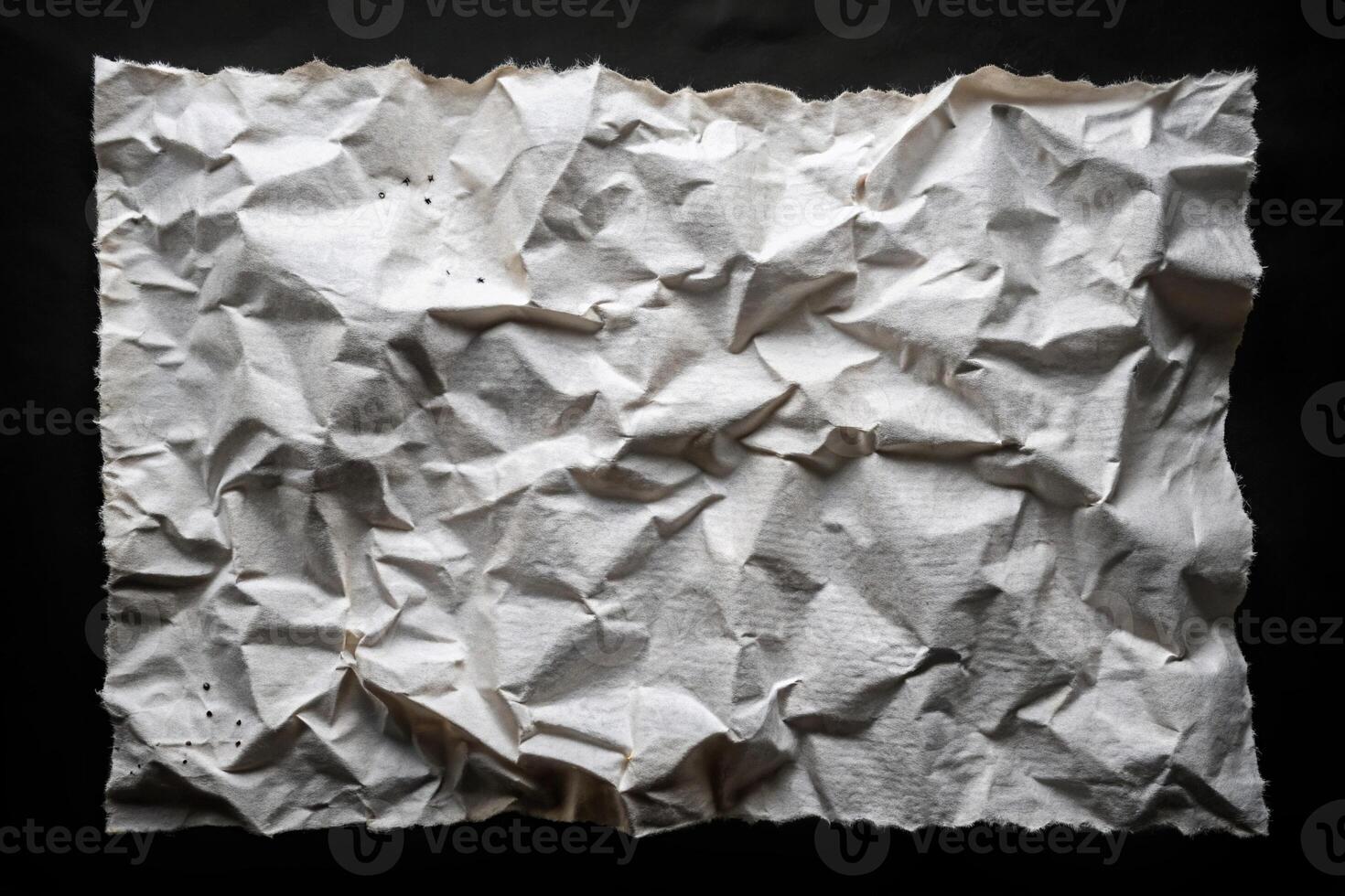 Crumpled and torn perforated paper sheet isolated on black eye level photo