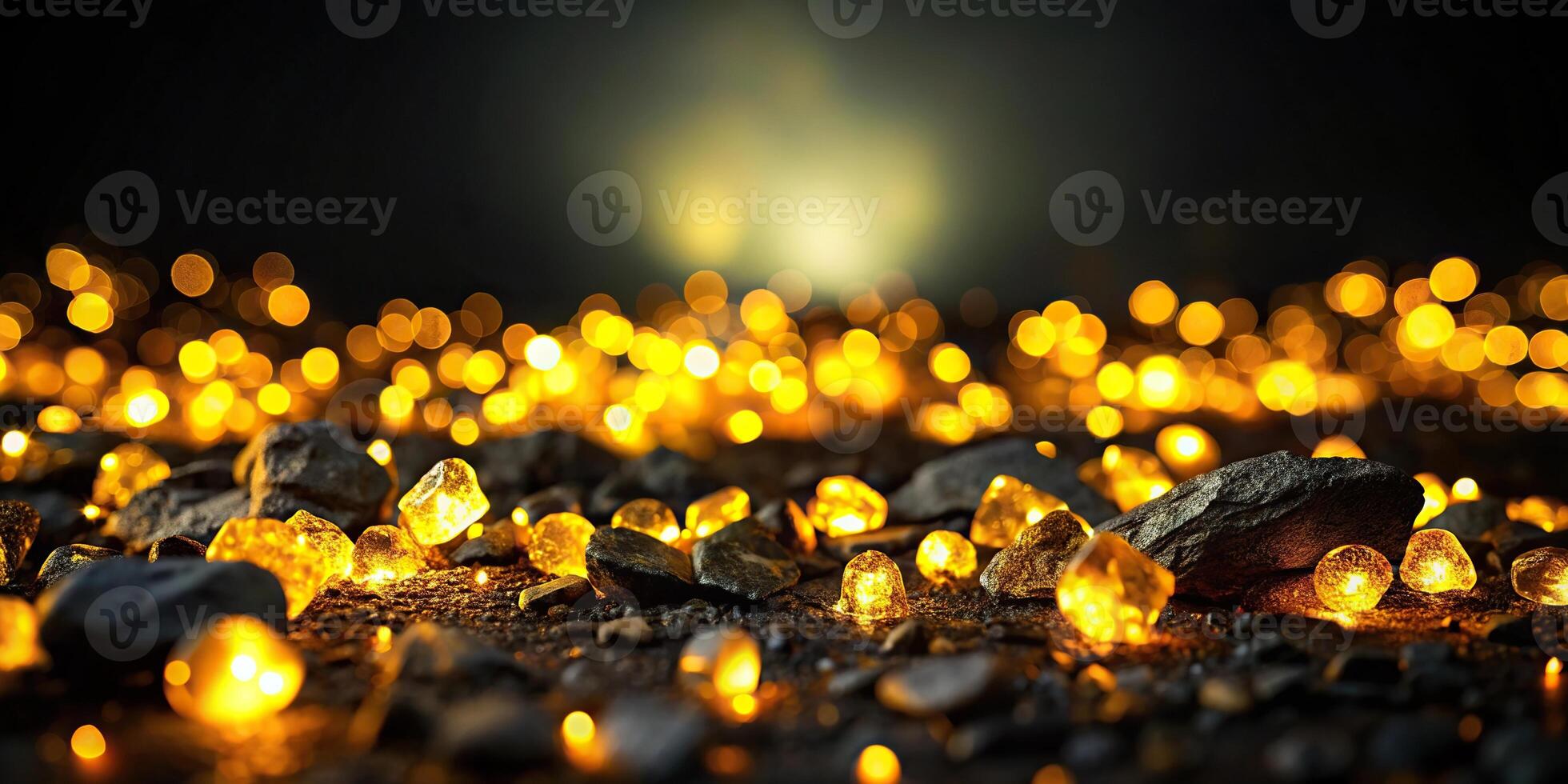 Dark background with yellow lights illuminating black rocks from a unique Worm's Eye View perspective photo