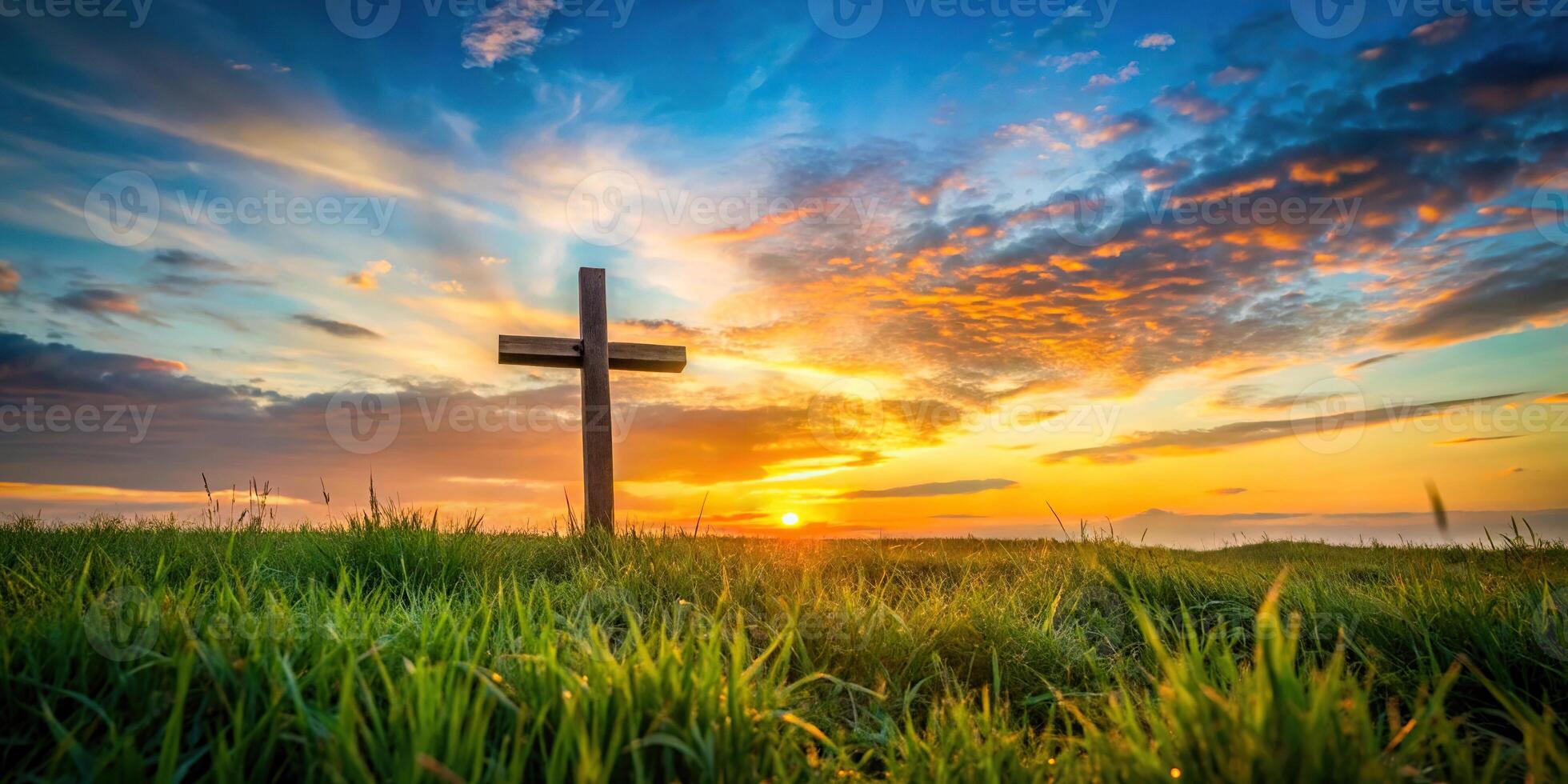 Cross on meadow with autumn sunrise in worm's eye view perspective photo
