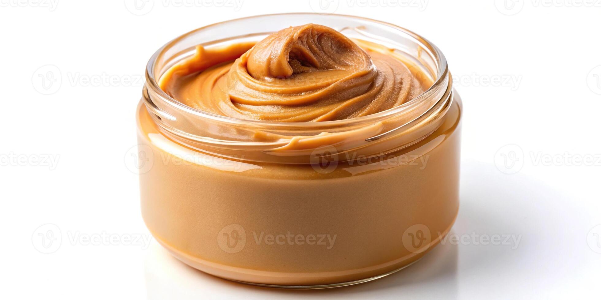 Creamy peanut butter spreading into a jar on white background photo