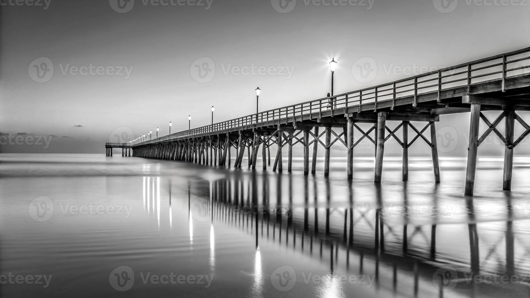 Panoramic black and white image of a fishing pier at dawn on the Atlantic Ocean photo