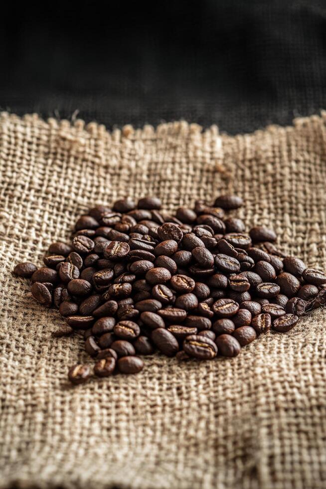 Freshly roasted coffee beans spread on burlap fabric in natural light just after brewing photo