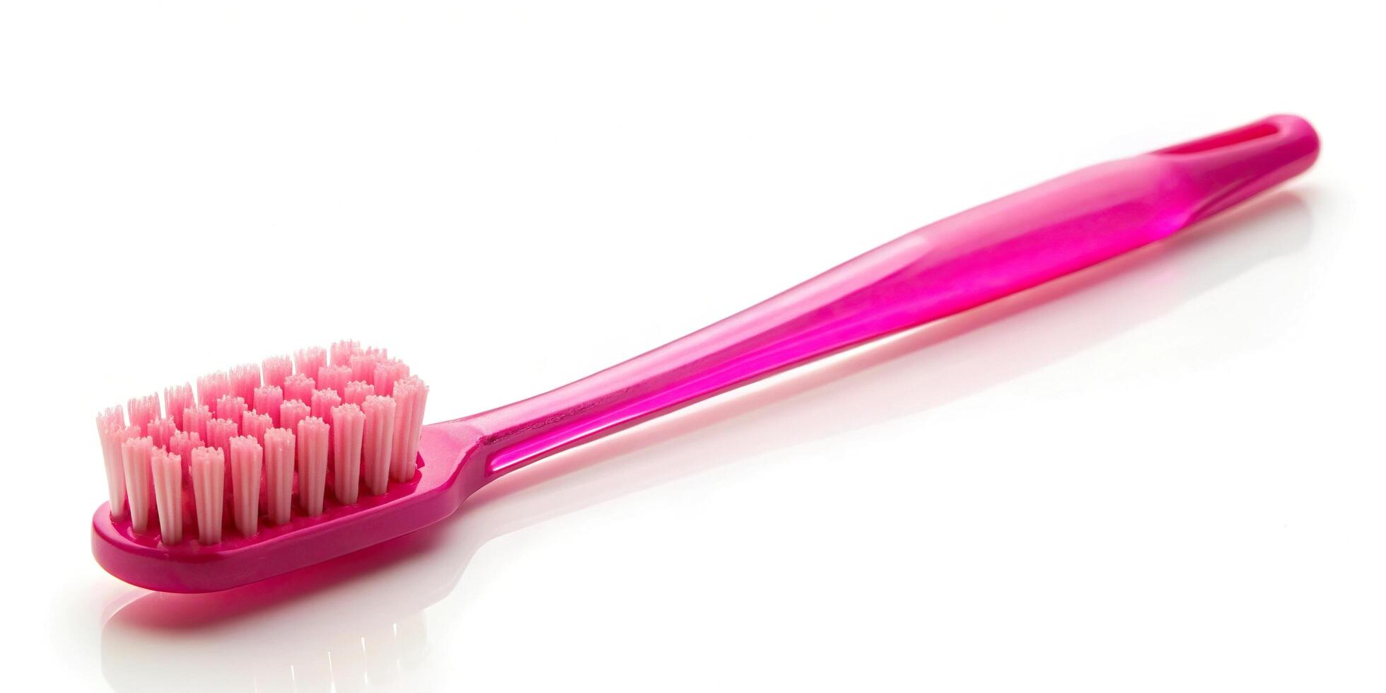 pink plastic toothbrush isolated on white macro photo