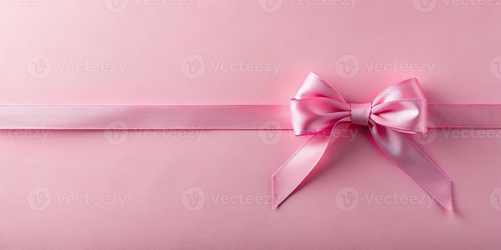 pastel pink ribbon with bow on pink background photo