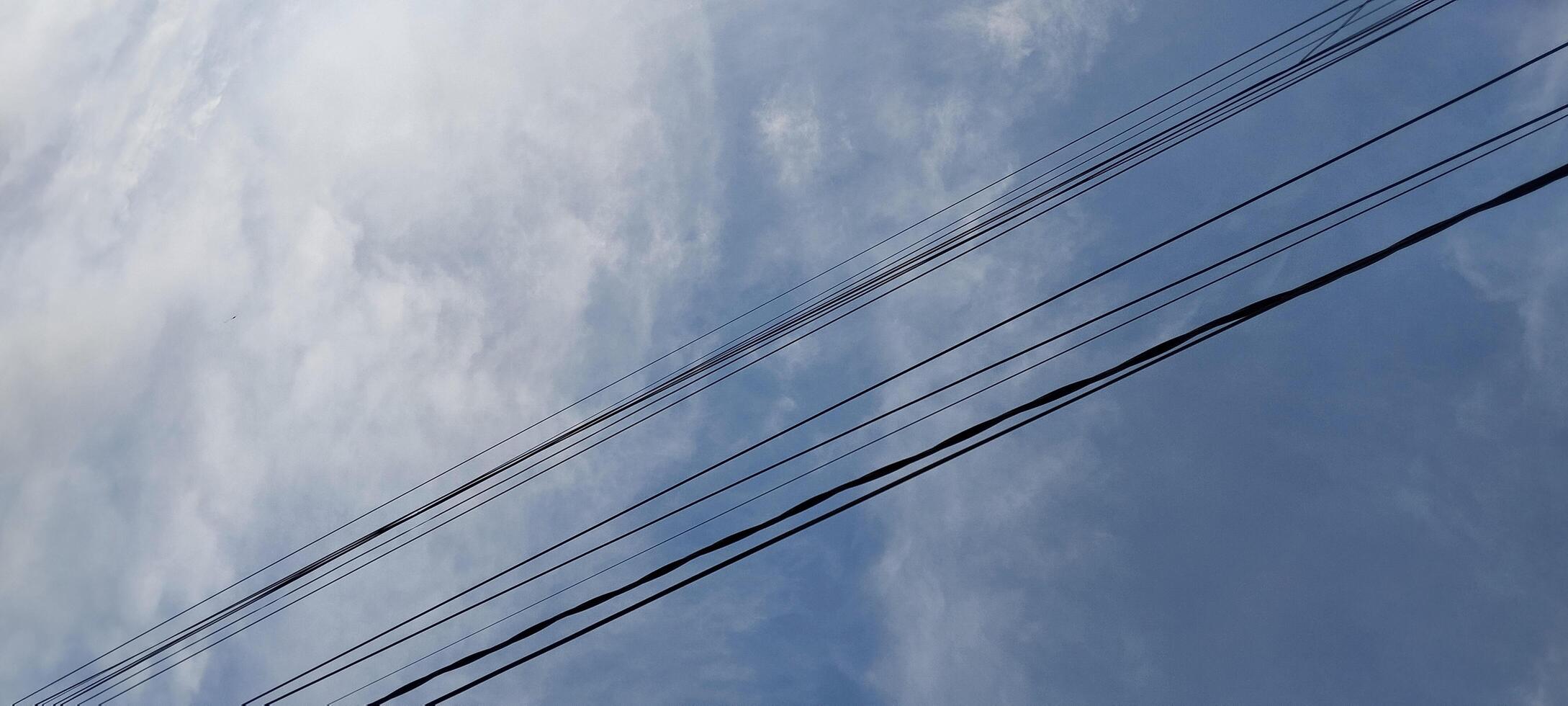 A view of a power line and a sky with clouds photo