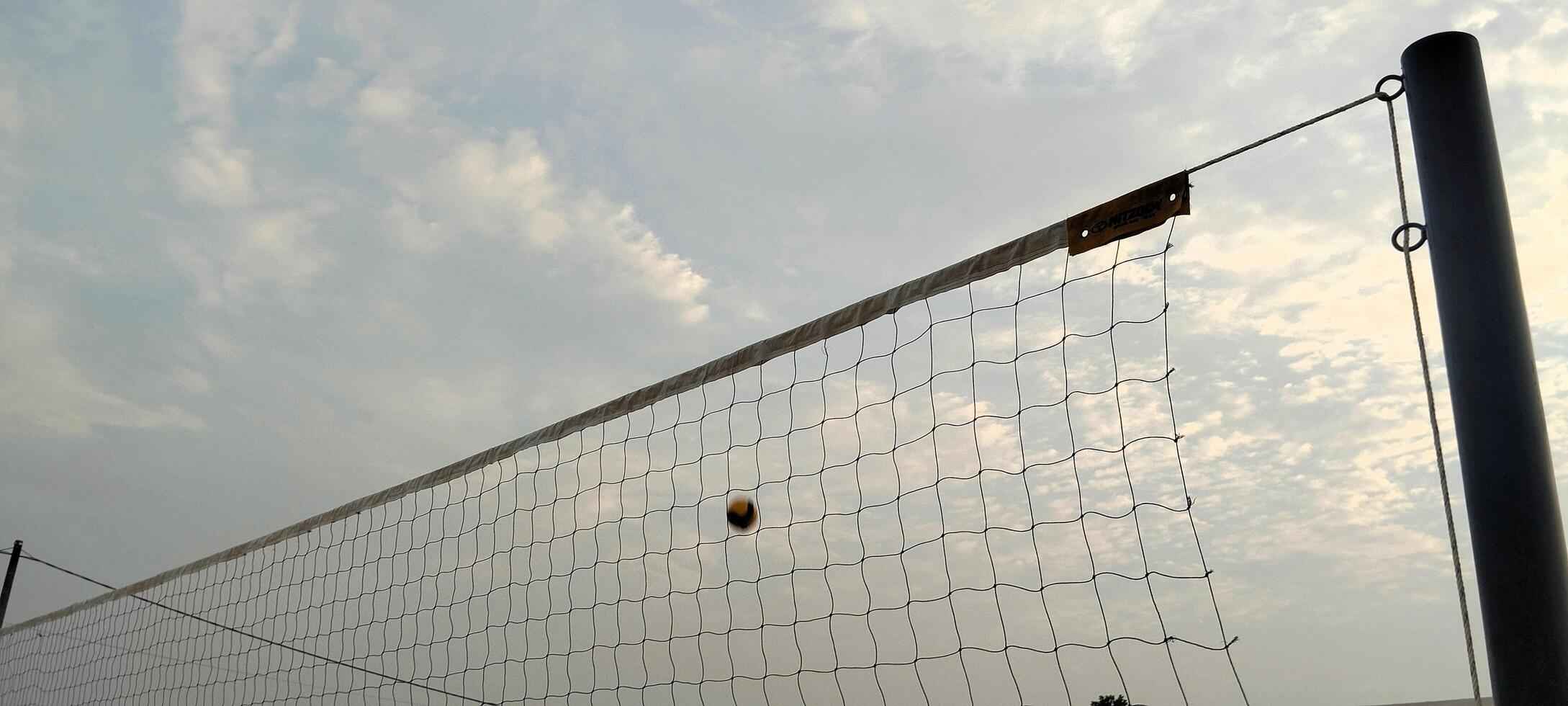 a volleyball net is in the air on a cloudy day photo