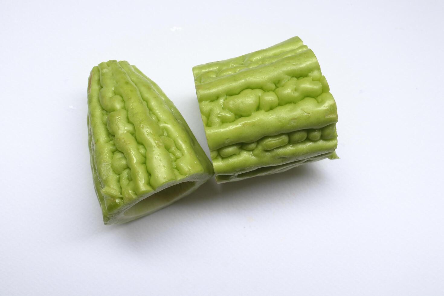 Light green pieces of Momordica charantia fruit on white background. Another name is Chinese bitter gourd, Balsam pear, Bitter cucumber, Bitter gourd, Leprosy gourd. photo