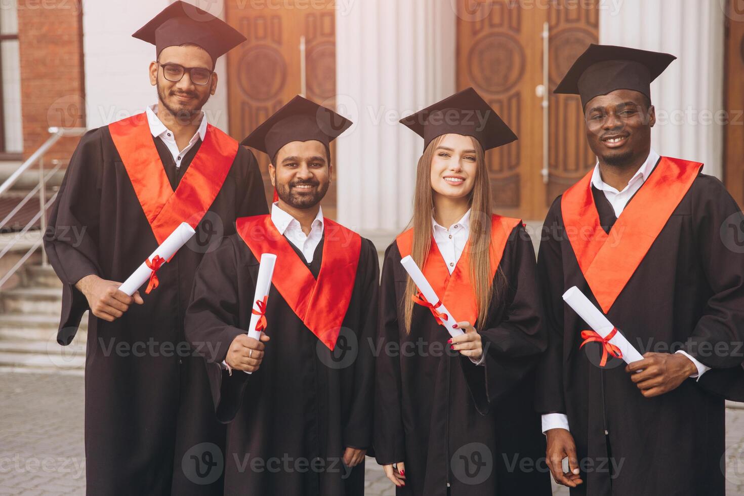 Group of Happy Graduates in Cap and Gown Celebrating Achievement Outdoors photo