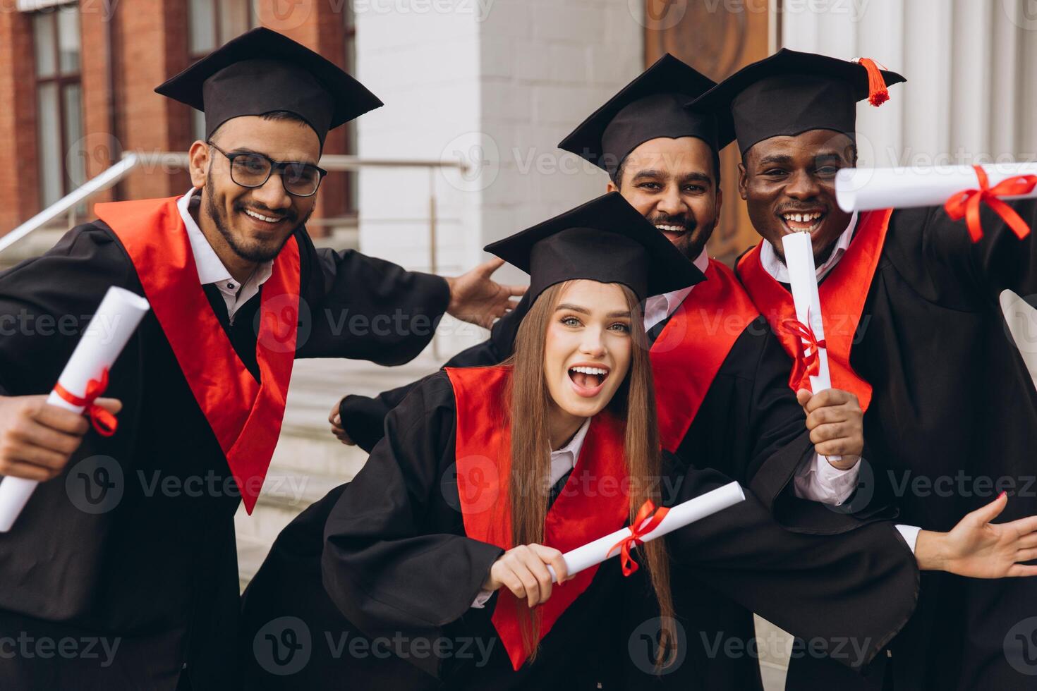 Group of Happy Graduates Celebrating with Diplomas in Hand on Graduation Day photo