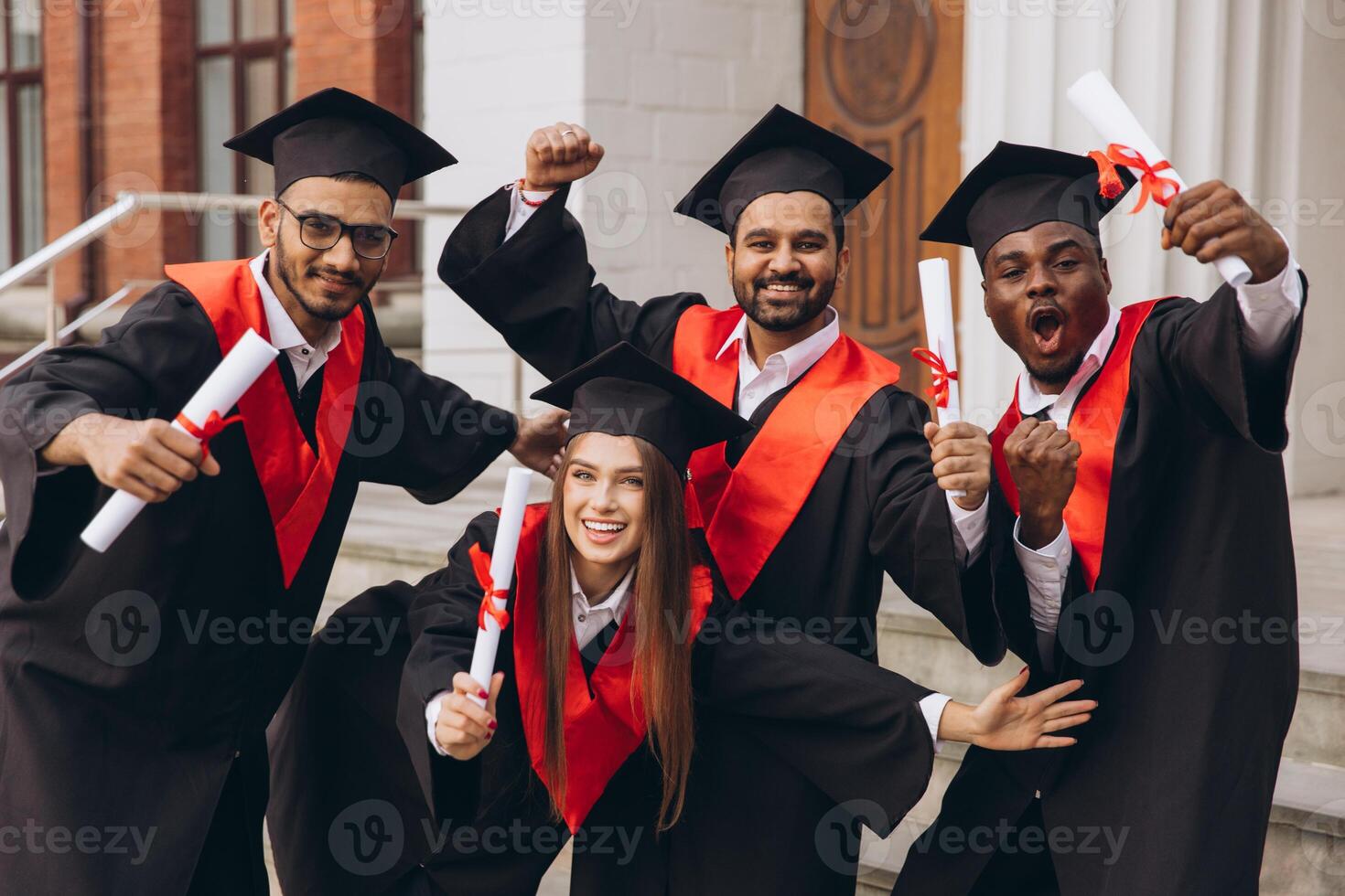 Celebratory College Graduation Group with Happy Students Holding Diplomas in Cap and Gown photo