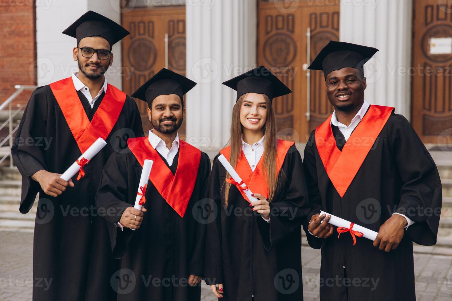 Group of Diverse Graduates Celebrating in Traditional Caps and Gowns Outdoors photo