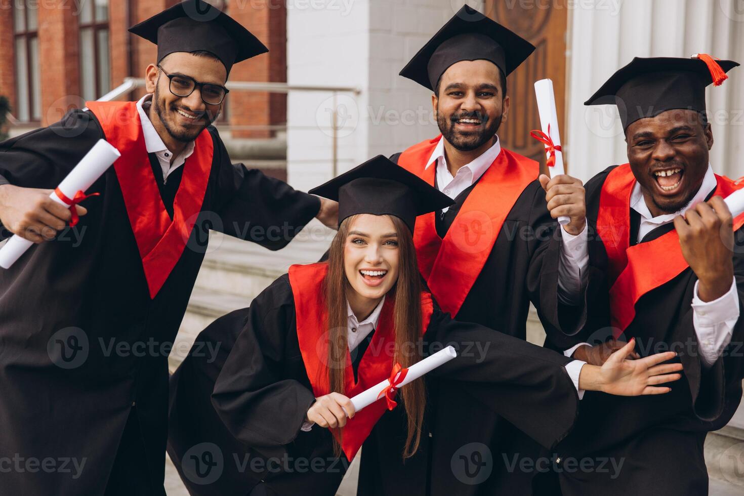 Group of Happy Graduates Celebrating with Diplomas in Hand on Graduation Day photo