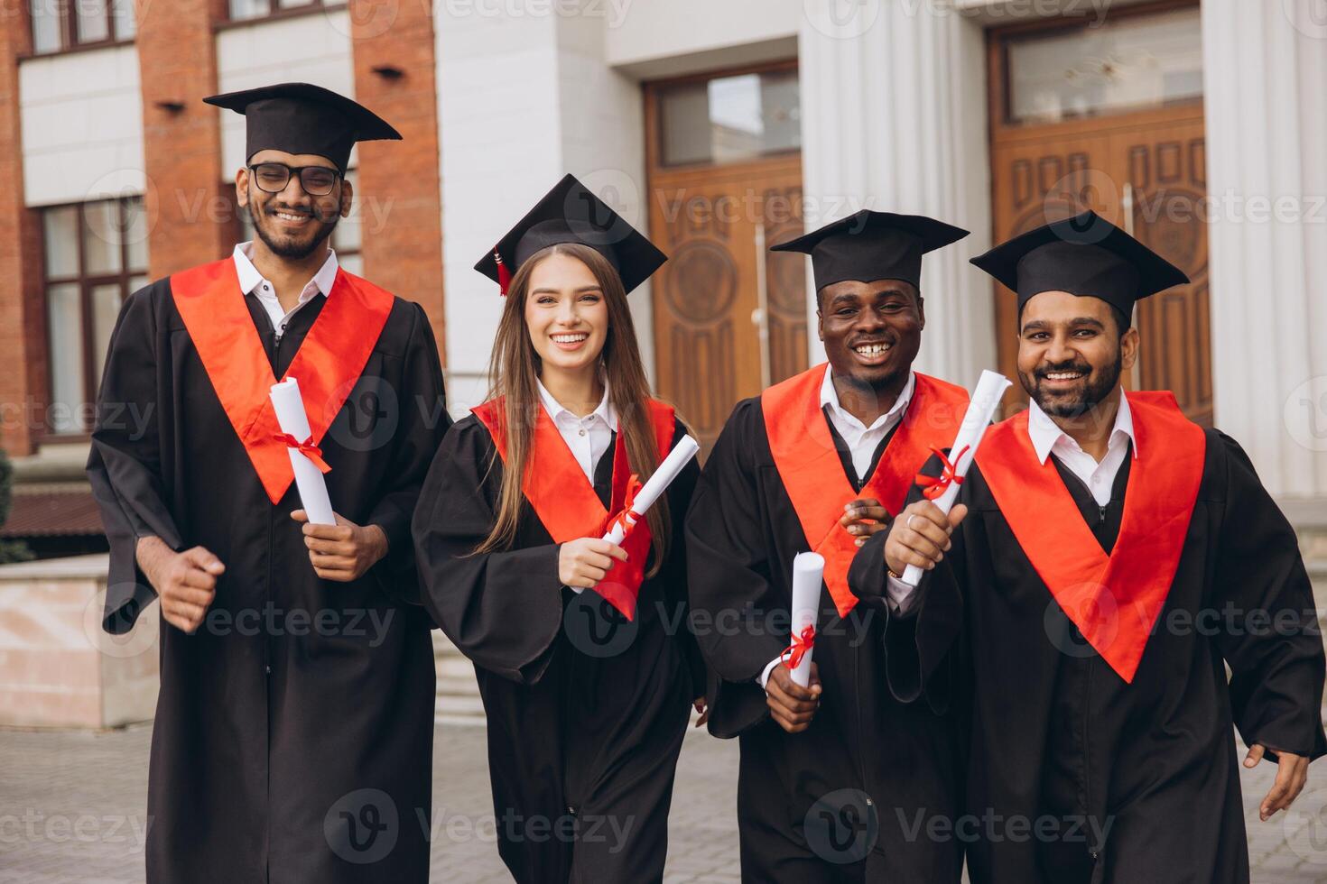 Joyful Group of Graduates Celebrating Their Academic Success in Caps and Gowns Outside the University photo