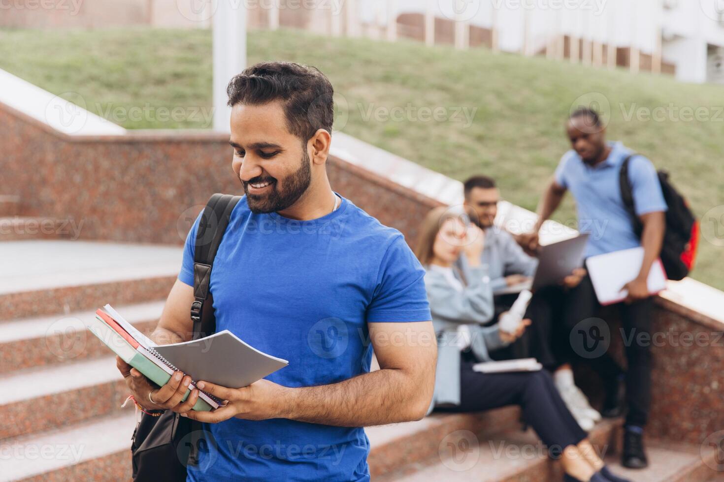 Smiling Indian Student with Books on College Campus Steps Enjoying Study Time photo