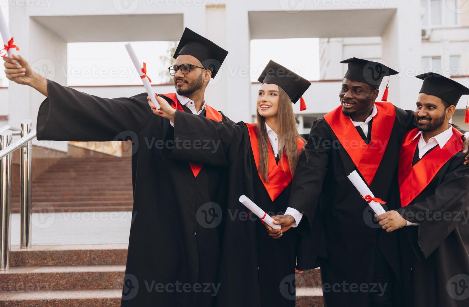 Diverse Group of Happy Graduates Celebrating Achievement with Diplomas in Academic Caps and Gowns Outdoors photo