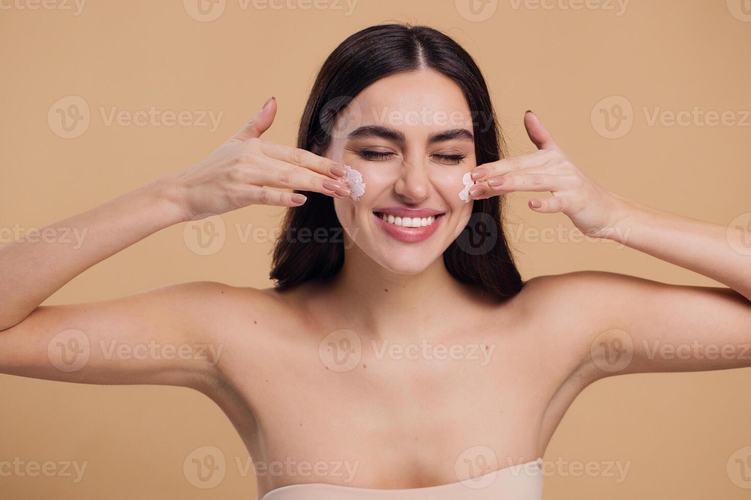 Woman beauty happy face close-up applying cream and cleanse skin photo