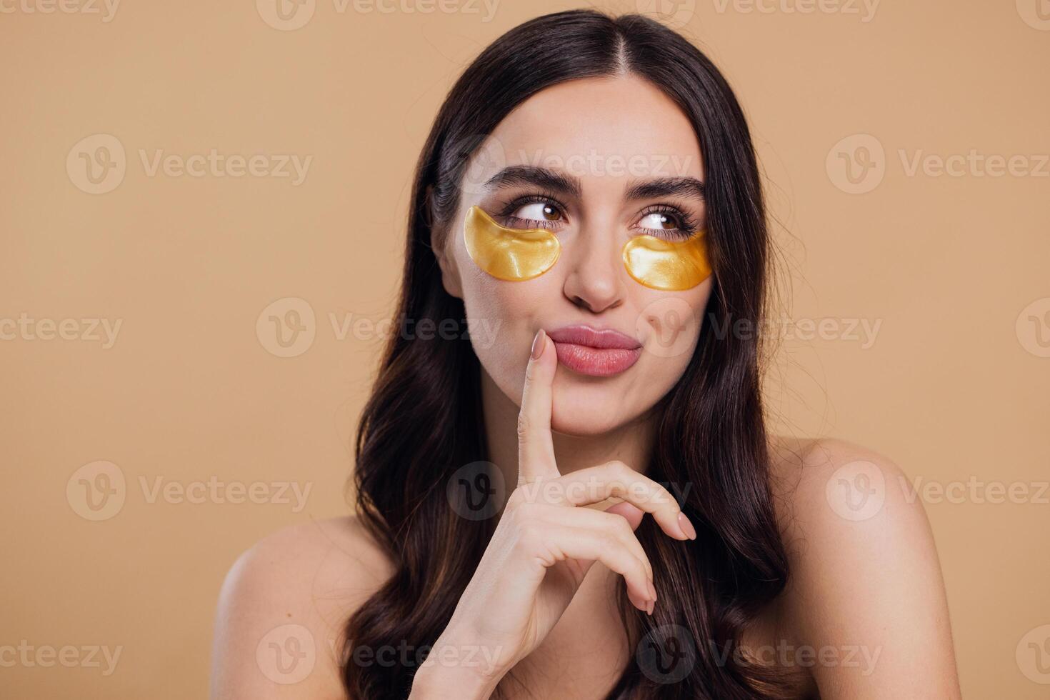 Woman standing naked isolated looking camera take care of her skin with under eye patches photo