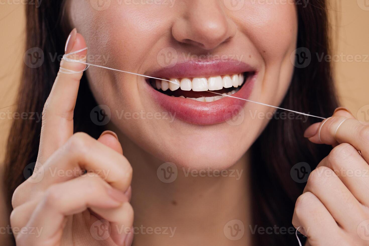 Beautiful Female Using Dental Floss And Smiling At Camera photo