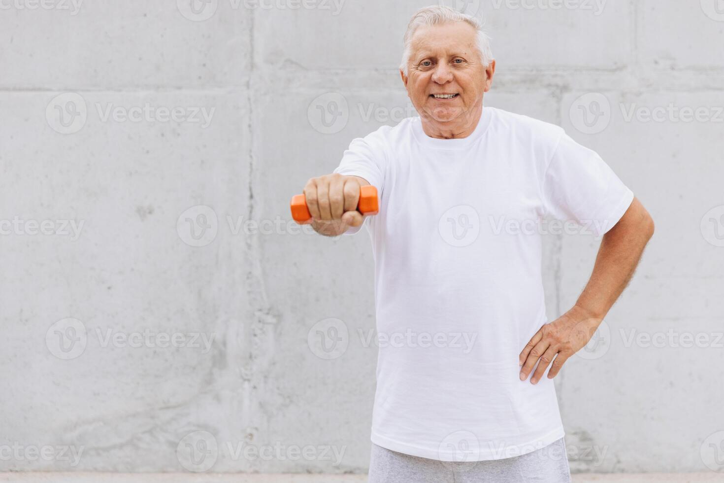 Happy Senior Man Exercising with Dumbbell in White T-shirt photo