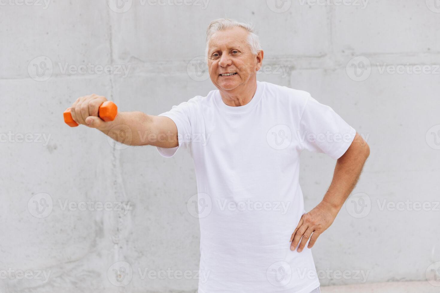 Happy Senior Man Exercising with Dumbbell in White T-shirt photo