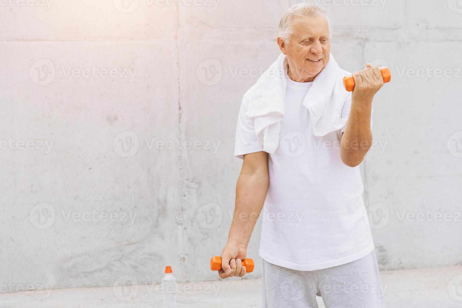 Senior Man Exercising with Dumbbells Outdoors in Casual Clothing photo