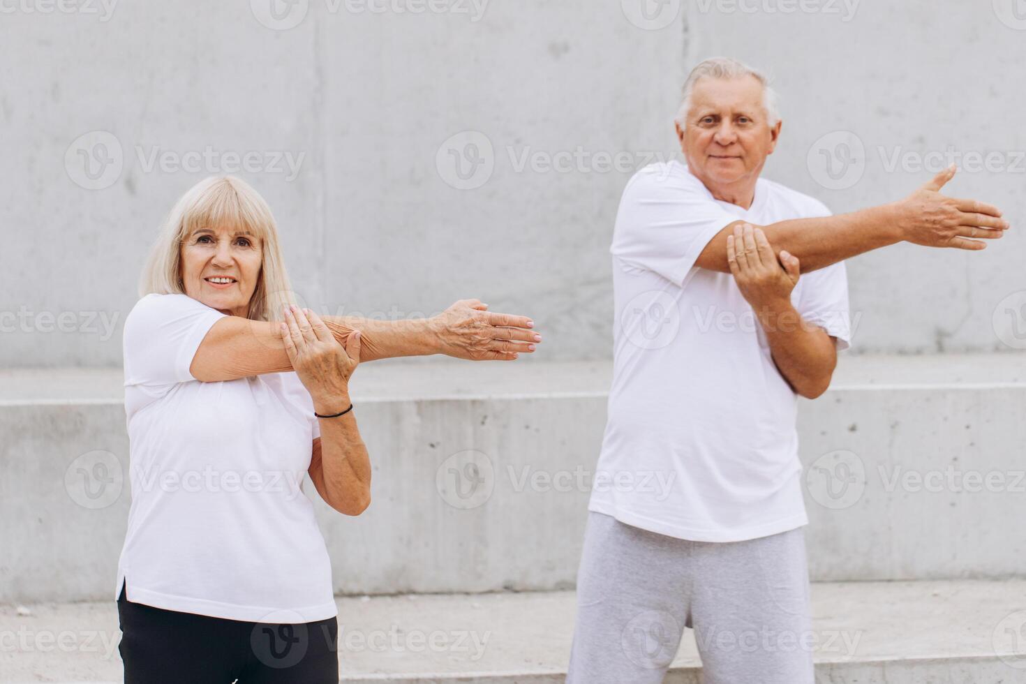 Senior Couple Exercising Outdoors Stretching Arms for Healthy Lifestyle photo