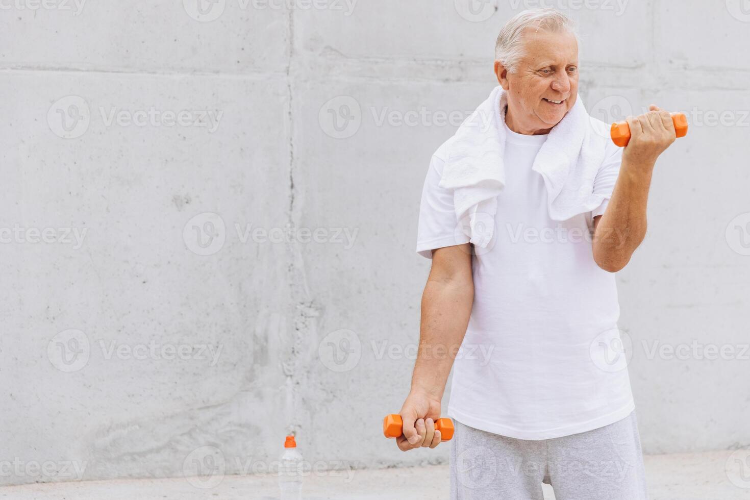 Senior Man Exercising with Dumbbells Outdoors in Casual Clothing photo