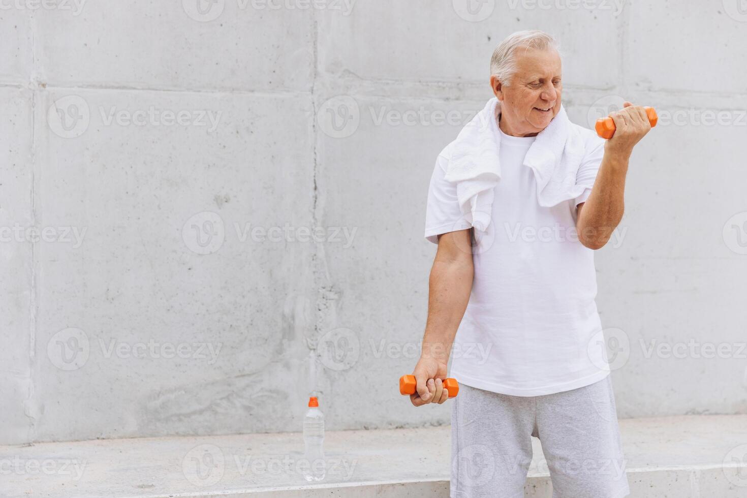 Senior Man Exercising with Dumbbells Outdoors in Casual Clothing photo
