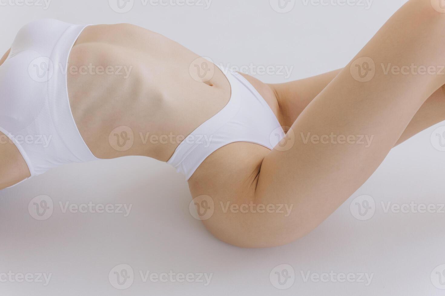 Close-up of Part of Ideal Female Body, Slim Woman in White Underwear Lying Down on Back, Happy Dreaming Girl Isolated over White Background with Copy Space, Mock-up. Beauty photo