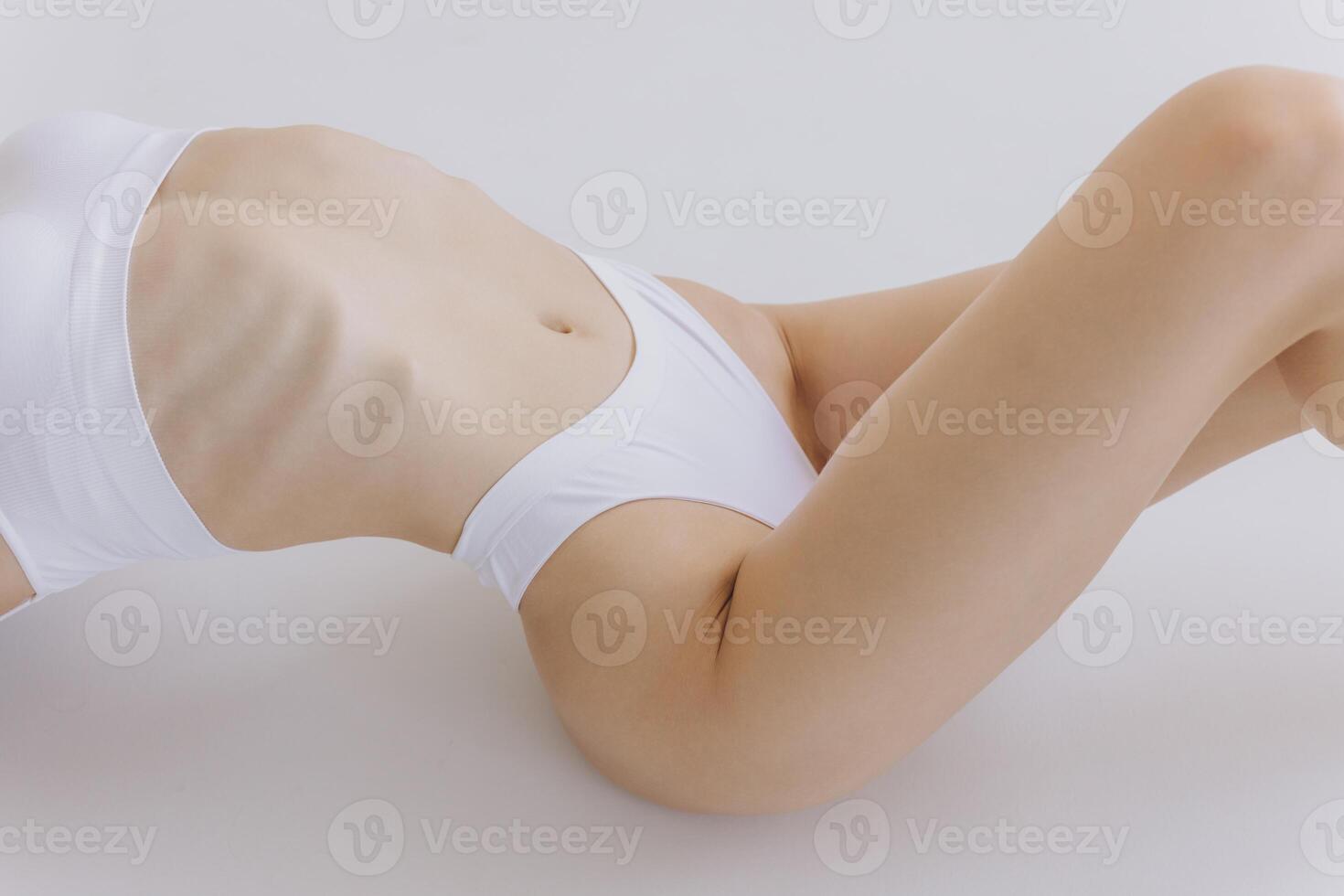 Close-up of Part of Ideal Female Body, Slim Woman in White Underwear Lying Down on Back, Happy Dreaming Girl Isolated over White Background with Copy Space, Mock-up. Beauty photo