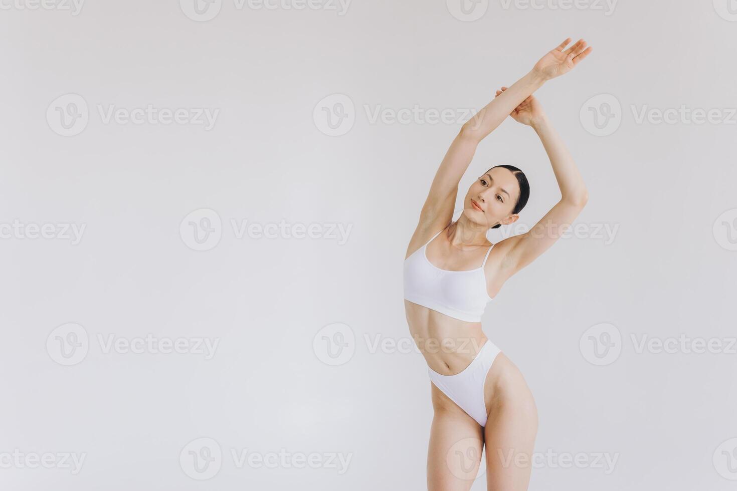 Portrait of beautiful woman with slim body in underwear posing in the white studio background with copy space, mock-up photo