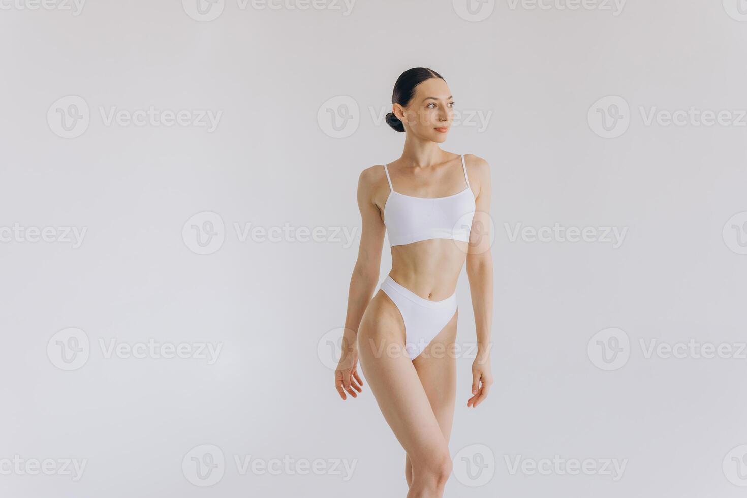Portrait of beautiful woman with slim body in underwear posing in the white studio background with copy space, mock-up photo