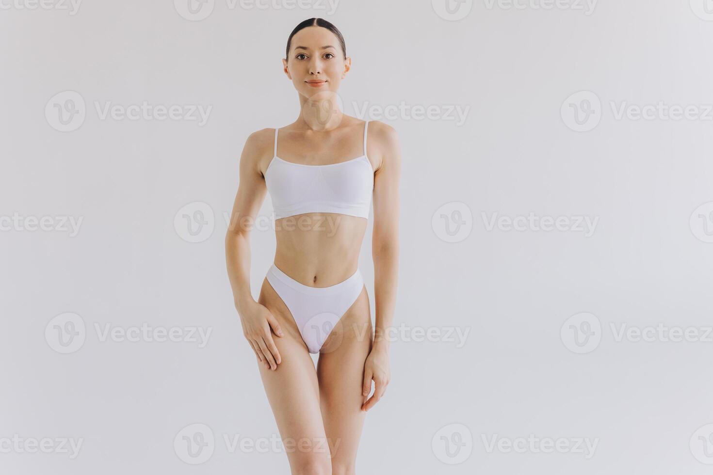 Portrait of beautiful woman with slim body in underwear posing in the white studio background with copy space, mock-up photo