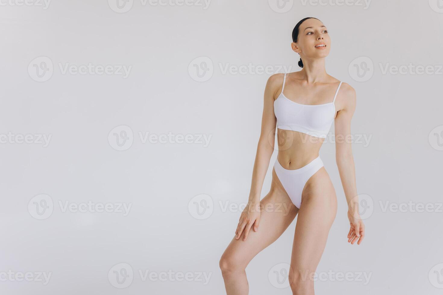 Portrait of beautiful woman with slim body in underwear posing in the white studio background with copy space, mock-up photo