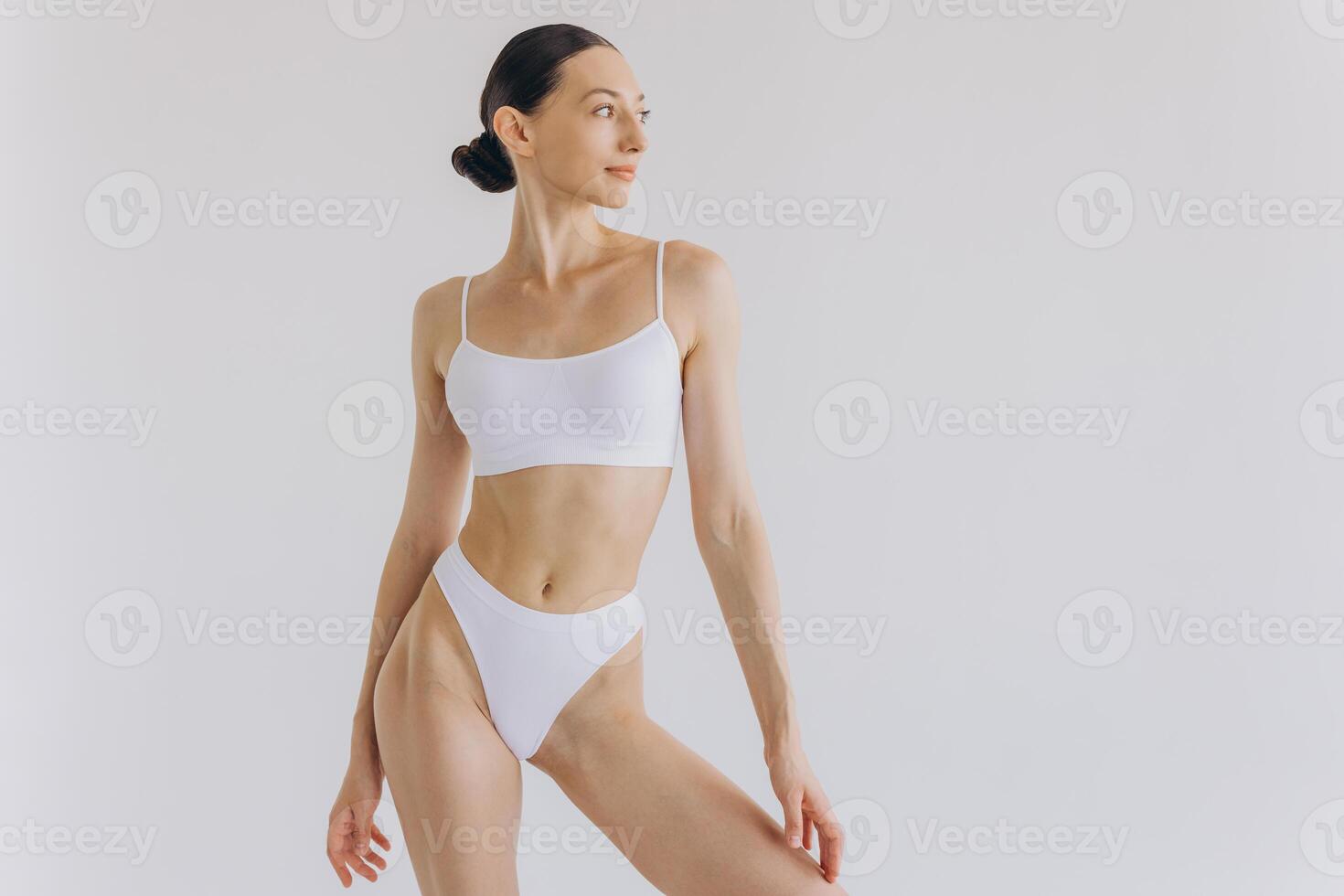 Portrait of beautiful woman with slim body in underwear posing in the white studio background with copy space, mock-up photo