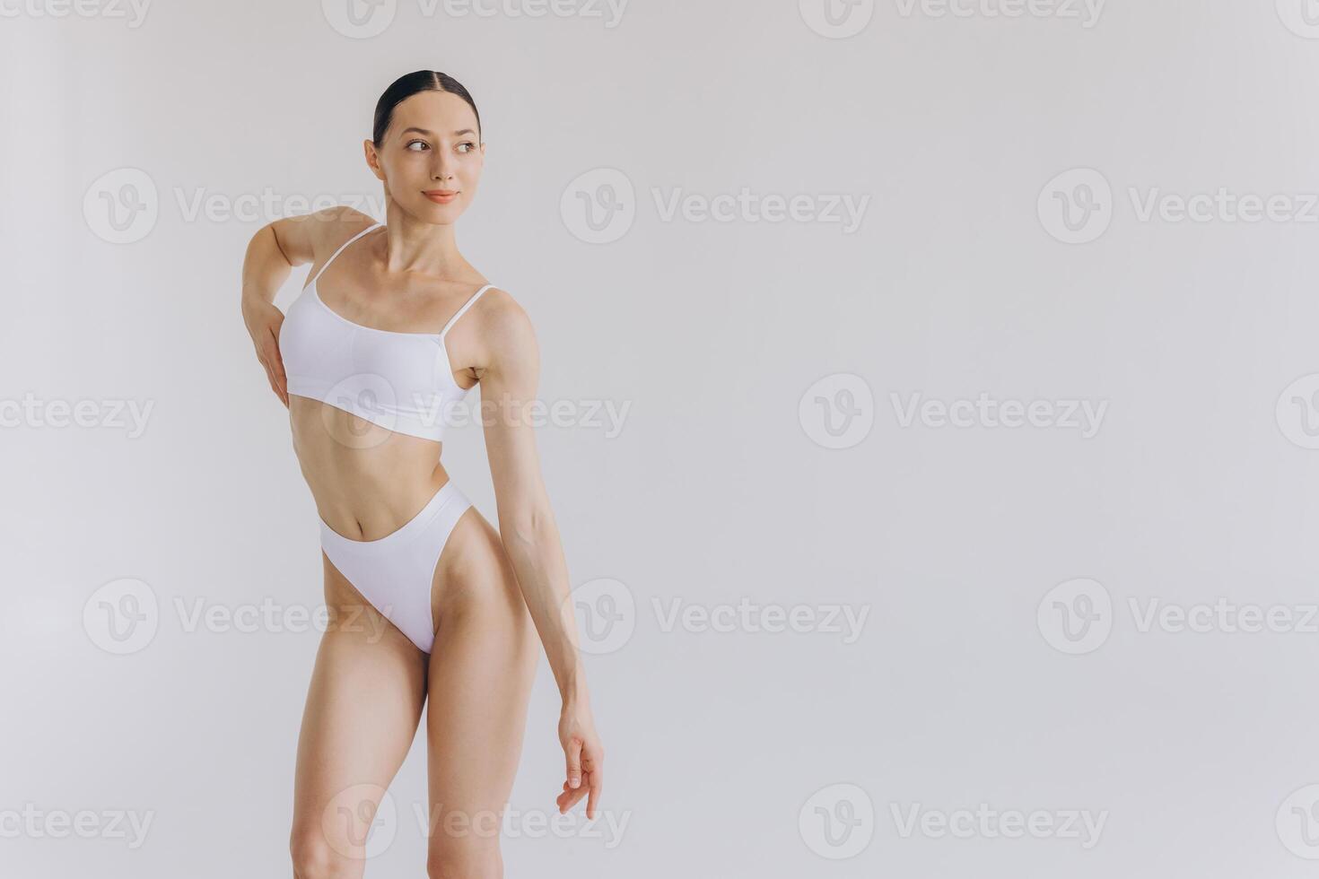 Portrait of beautiful woman with slim body in underwear posing in the white studio background with copy space, mock-up photo