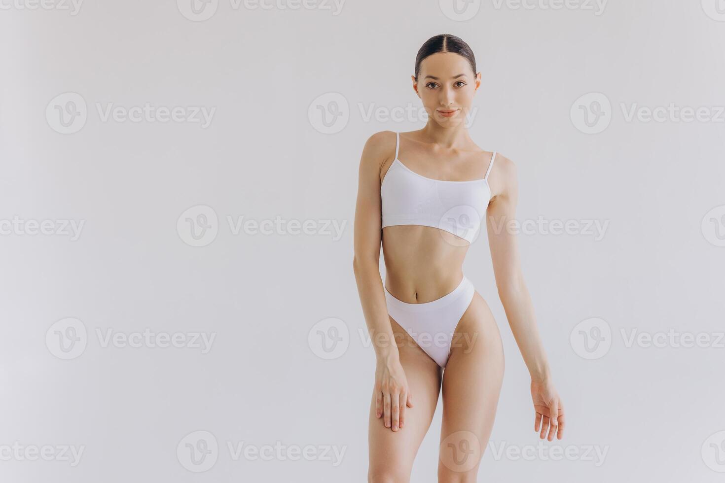 Portrait of beautiful woman with slim body in underwear posing in the white studio background with copy space, mock-up photo