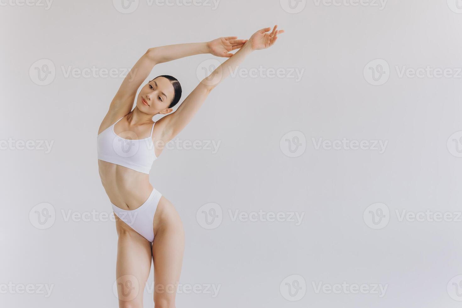 Portrait of beautiful woman with slim body in underwear posing in the white studio background with copy space, mock-up photo