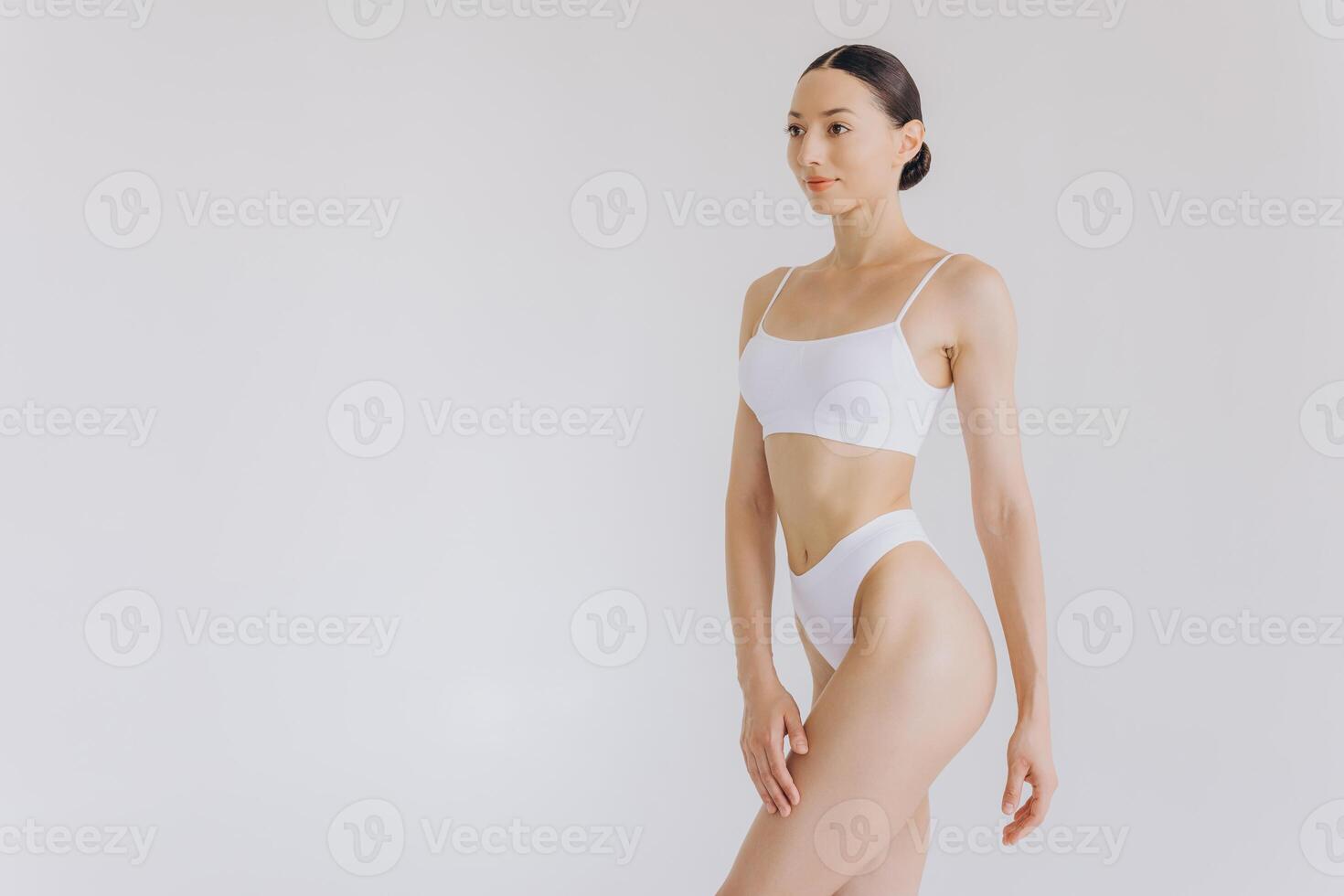 Portrait of beautiful woman with slim body in underwear posing in the white studio background with copy space, mock-up photo