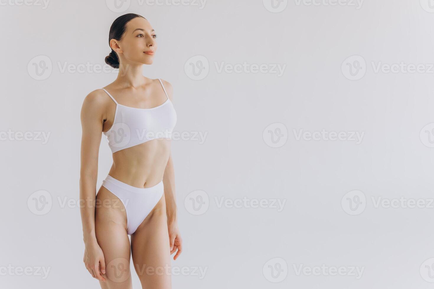 Portrait of beautiful woman with slim body in underwear posing in the white studio background with copy space, mock-up photo