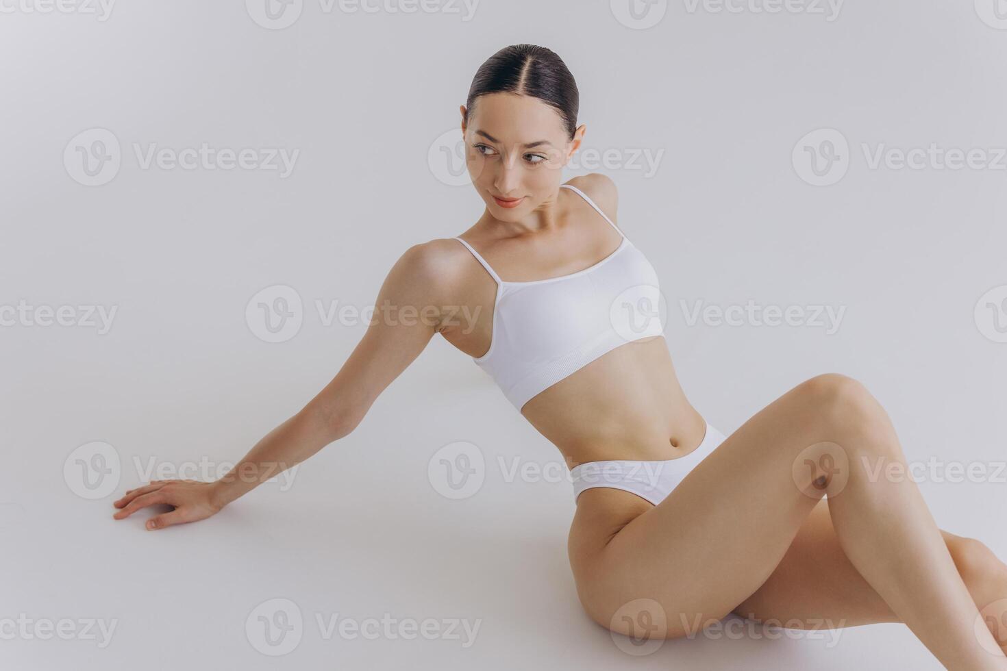 Fit and sporty beautiful woman with perfect shape. Girl in white underwear on the floor. Healthy lifestyle, sport, health care, nutrition and diet concept photo