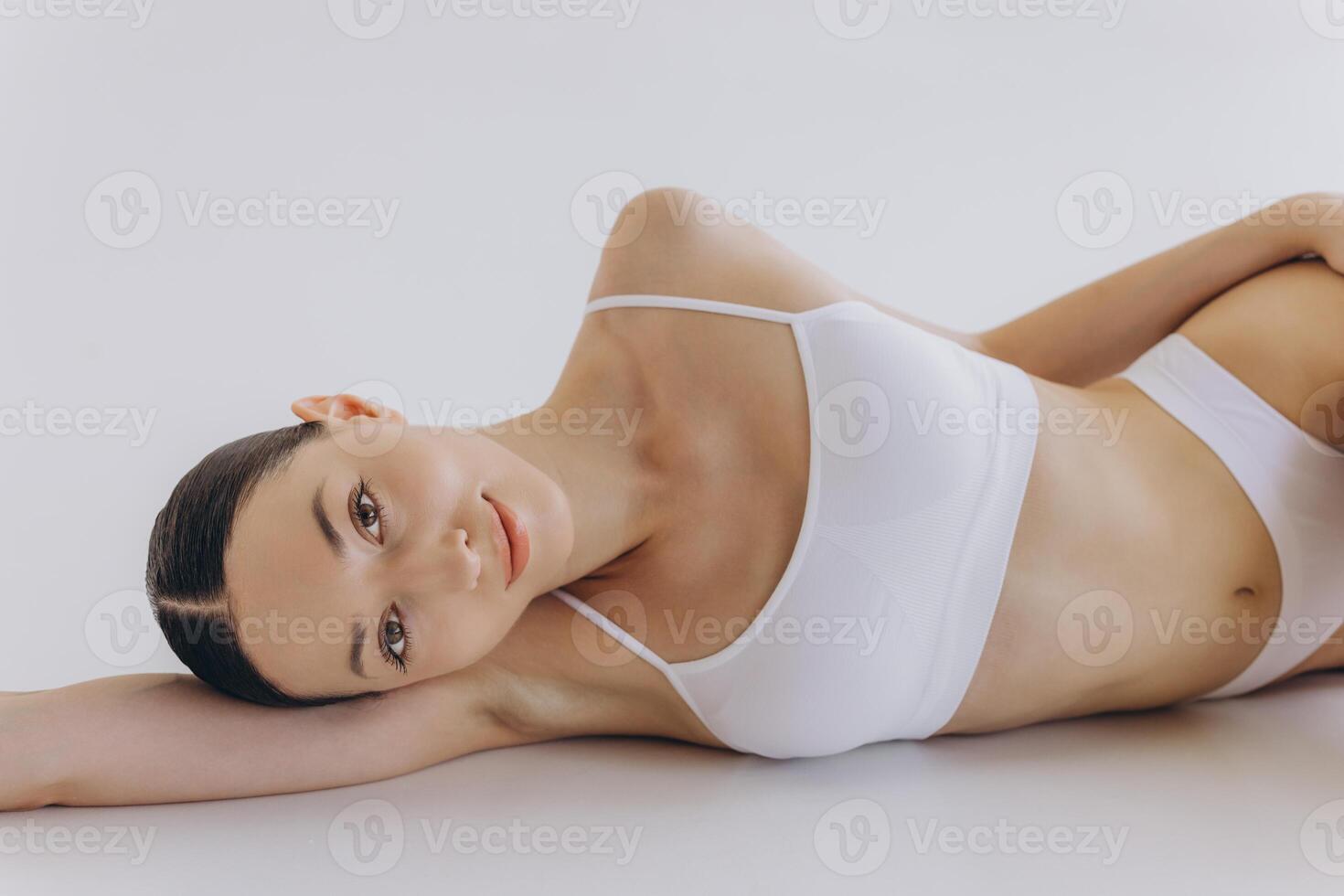 Body Beauty, Slim Woman in White Underwear Lying Down on Back, Happy Dreaming Girl Isolated over White Background with Copy Space, Mock-up photo