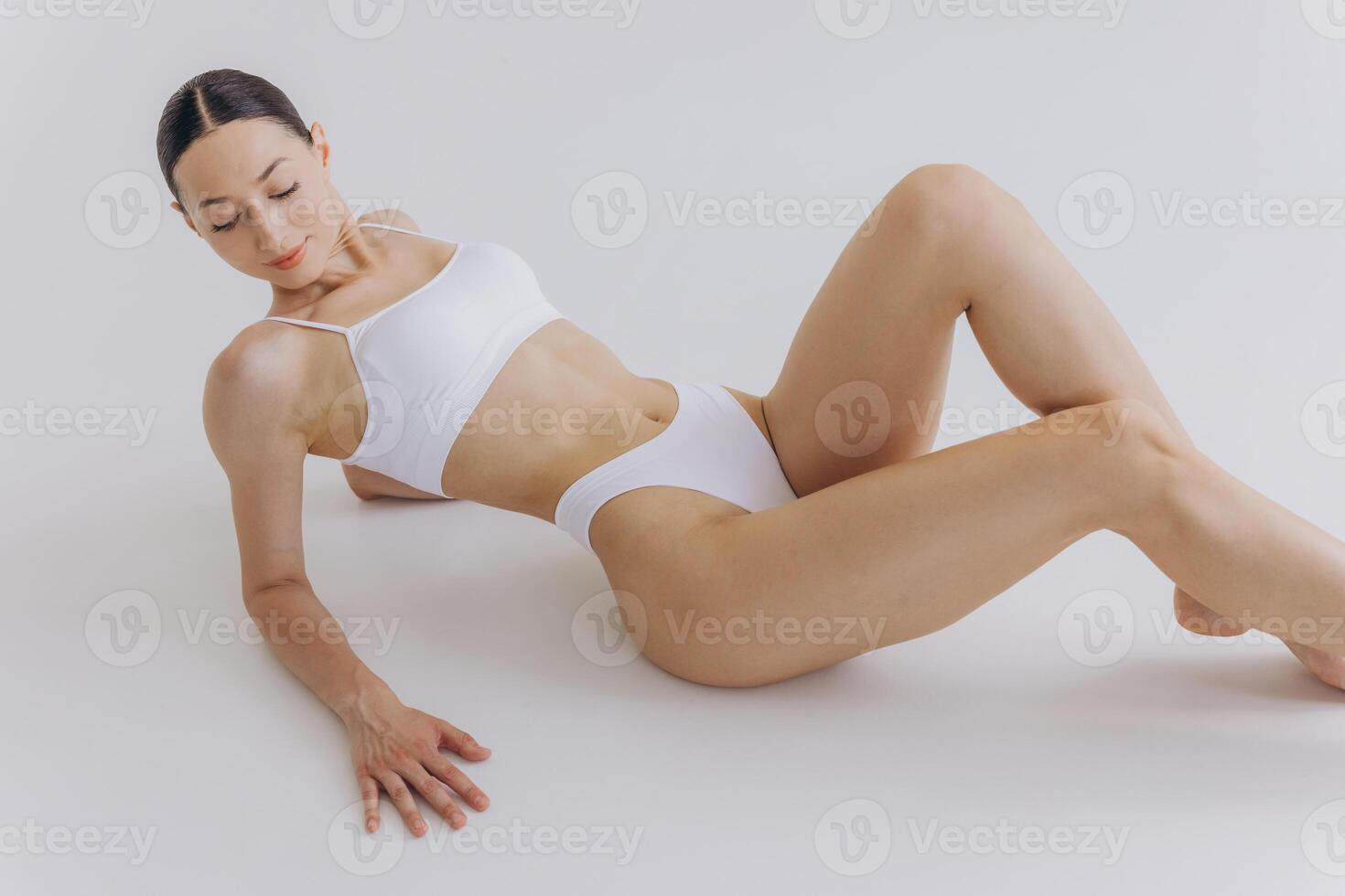 Body Beauty, Slim Woman in White Underwear Lying Down on Back, Happy Dreaming Girl Isolated over White Background with Copy Space, Mock-up photo