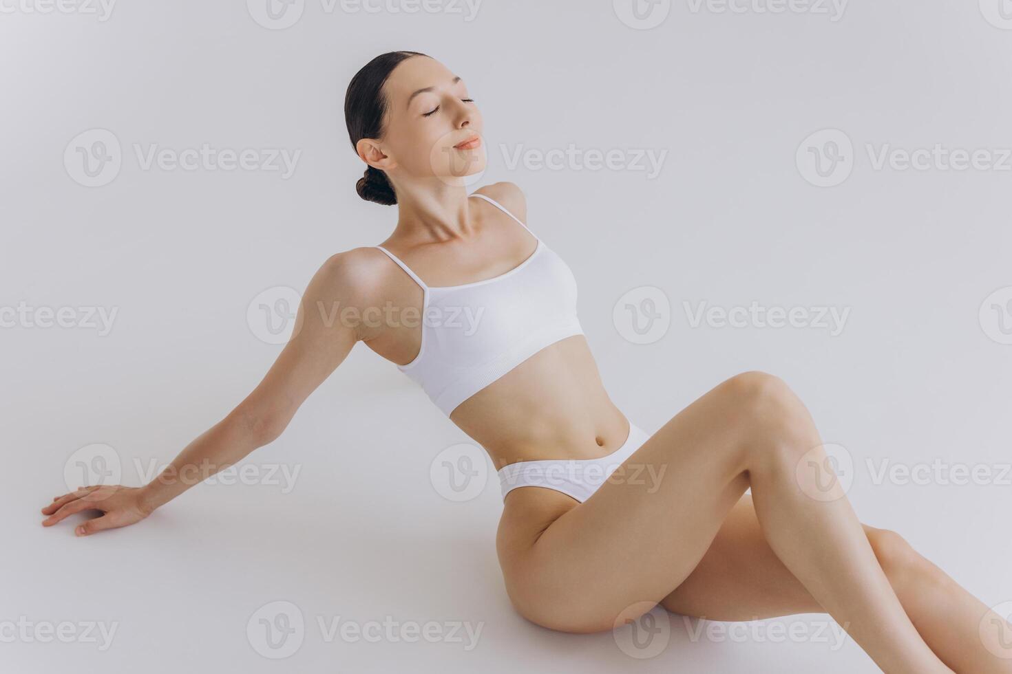 Fit and sporty beautiful woman with perfect shape. Girl in white underwear on the floor. Healthy lifestyle, sport, health care, nutrition and diet concept photo